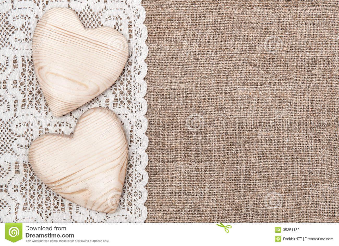 burlap background with white lacy cloth and wooden hearts dxxh2a clipart